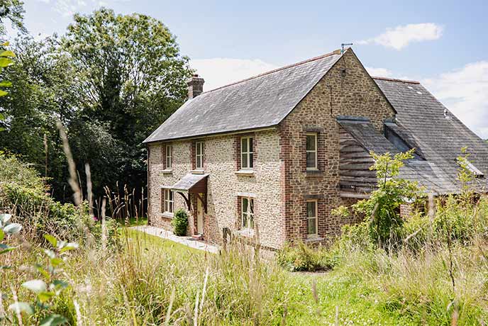 Beautiful stone farmhouse exterior surrounded by nature in Dorset