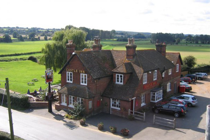 Looking down on the red bricked Castle Inn, which is surrounded by countryside