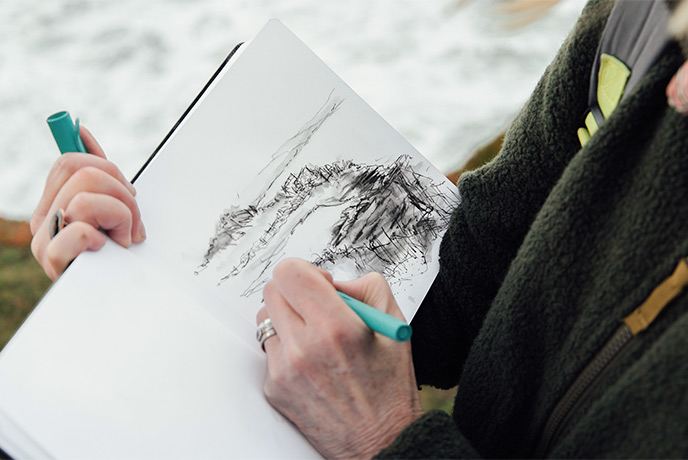 Emma Scattergood drawing on a coast path in Cornwall