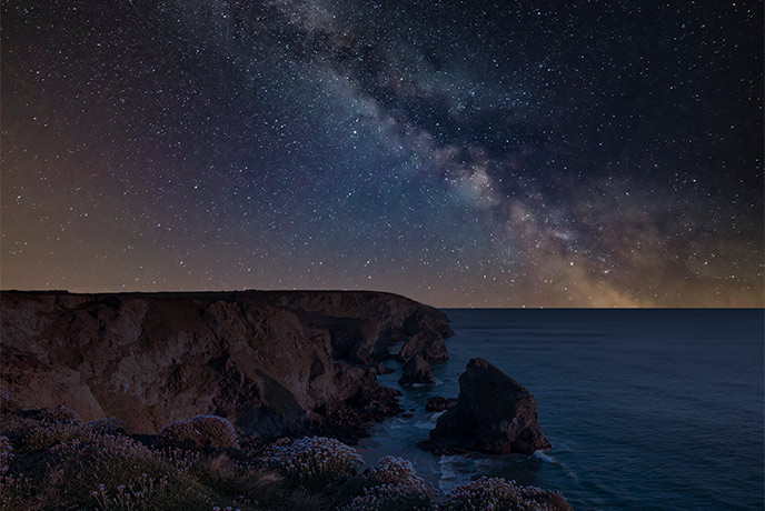 The dramatic coastline at Bedruthan Steps at night, perfect for stargazing