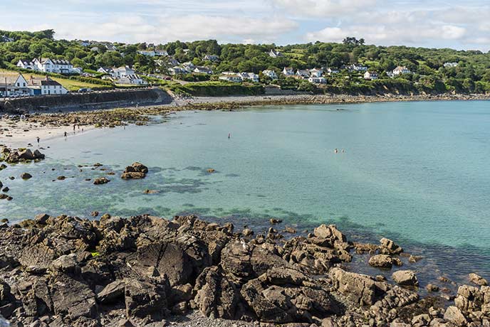Looking out over rocks and turquoise waters at Coverack Beach on the Lizard Peninsula