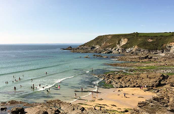 People playing in the turquoise waters of Dollar Cove in West Cornwall
