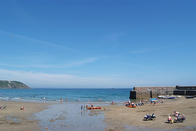 People walking along the beach at Gorran Haven