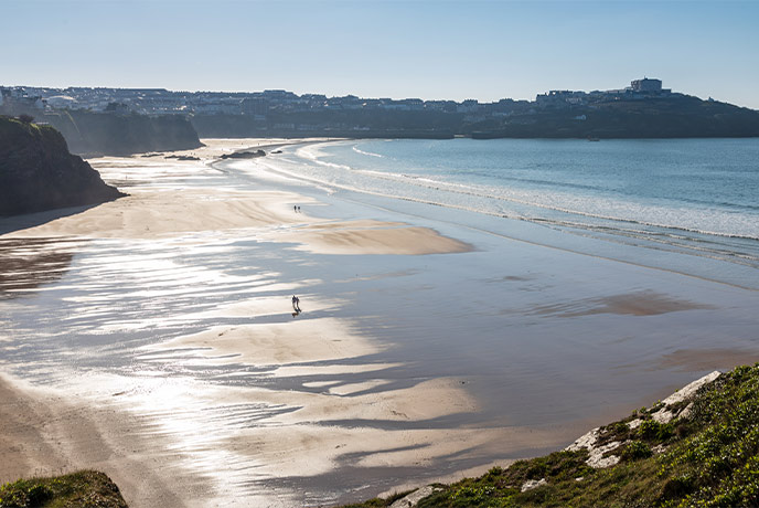 The stretching sands and towering cliffs at Great Western beach in Newquay