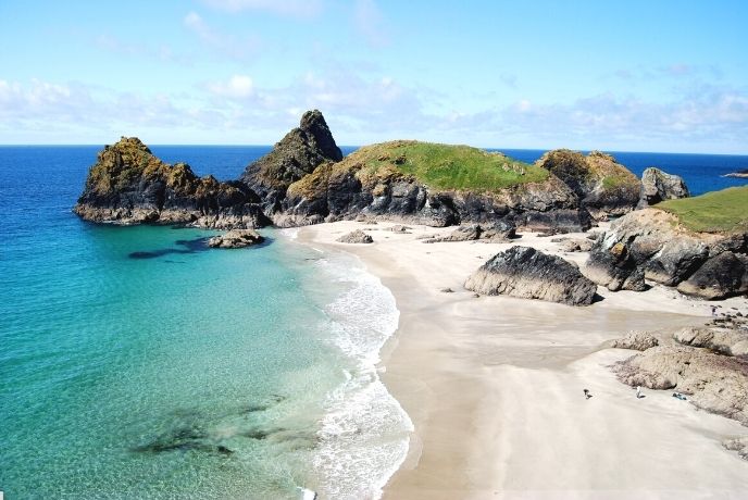 The blue waters and sandy beach at Kyncance Cove at low tide