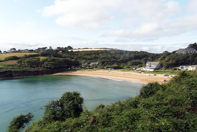 Looking across the see at the golden sands of Maenporth Beach in Falmouth