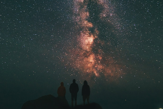 Three silhouettes standing in front of a starry sky at Ninjizal in Cornwall