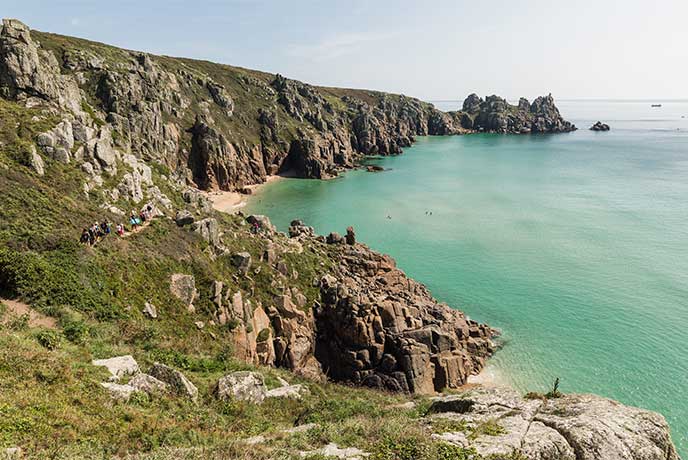 Looking across the rugged cliffs at the golden sands and clear blue seas at Pedn Vounder Beach in Cornwall