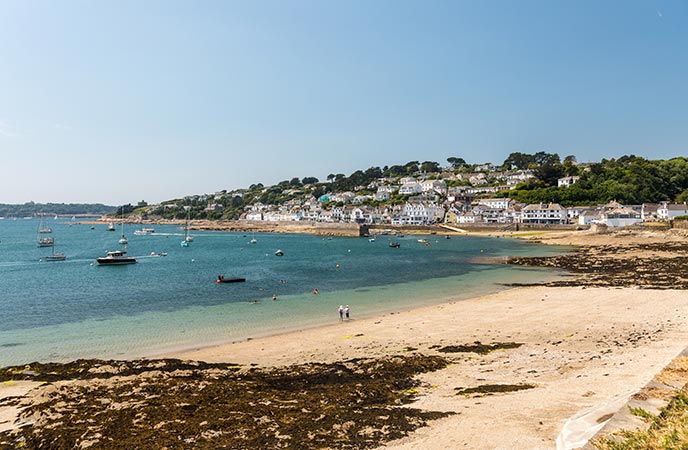 The golden sands of Summers Beach with the pretty village of St Mawes in the background