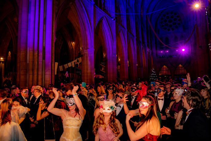 Masked people dancing inside Truro Cathedral at the incredible Cathedral Masquerade ball on New Year's Eve