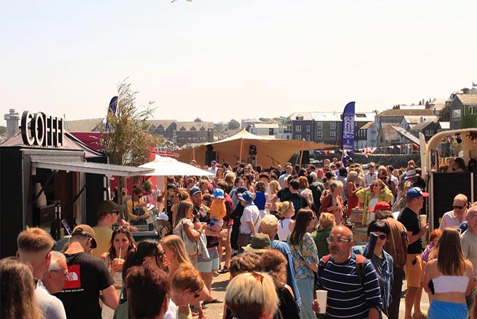 Crowds of people walking amongst the stalls at Falmouth Food Festival in Cornwall