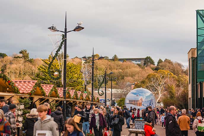 Lots of people walking past the stalls at Truro Christmas Market in Cornwall