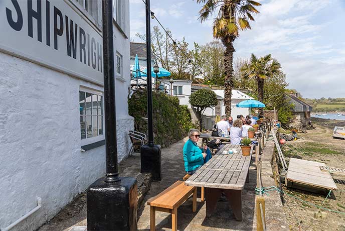 Outdoor tables overlooking the Helford River at The Shipwrights Arms in Helford