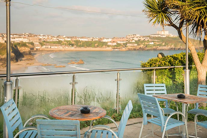 Outdoor tables looking out over the beach and sea at The Great Western's pub garden in Cornwall