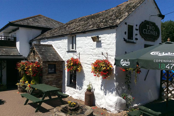 The white-walled exterior of The Two Clomes Inn, one of the cosiest pubs in Cornwall