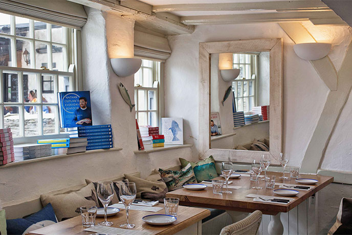 The quaint interior of Outlaw's Fish Kitchen, full of cookery books and charm