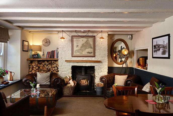 The cosy dining room at The Rising Sun, with tables, chairs and a fireplace