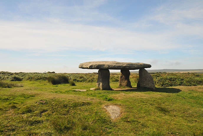 Stones balancing on one another in a field at Lanyan Quoit in Cornwall