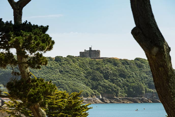 Looking across water and trees at Pendennis Castle in Falmouth