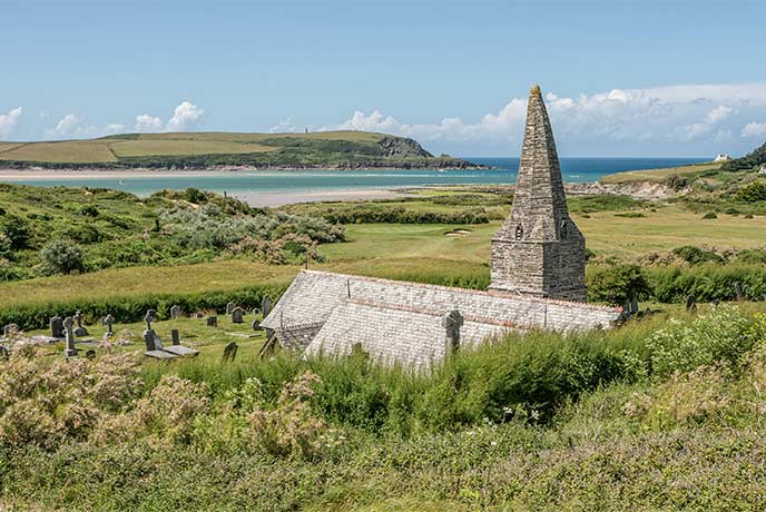 The beautiful St Enodoc Church looking out over fields towards the North coast of Cornwall