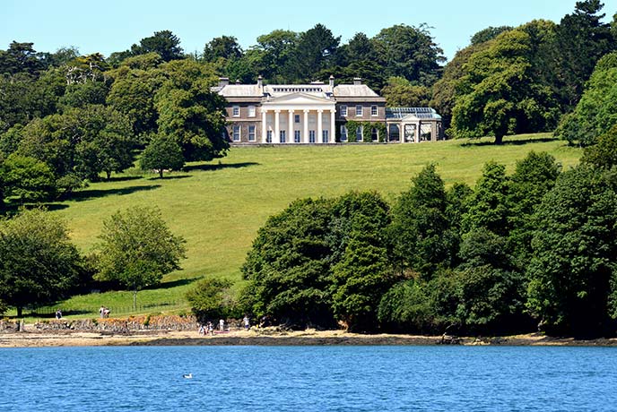 Looking across the water and up the grass at Trelissick House in Cornwall