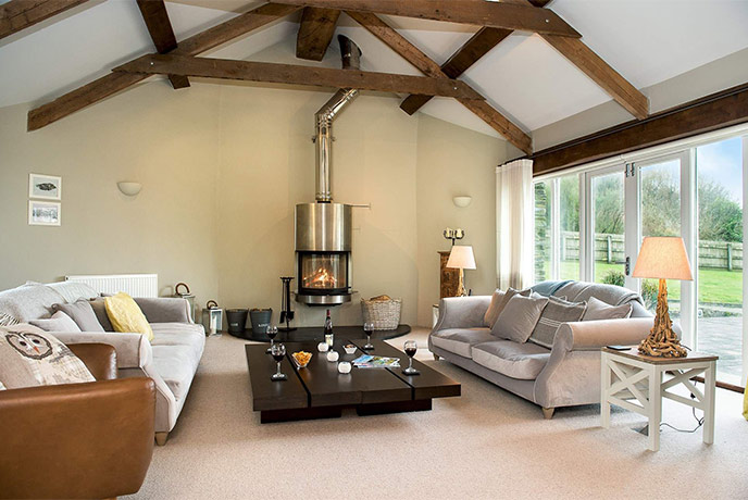 The stylish living room with a wood-burner at Mill Barn
