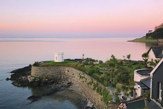 The beautiful coastal location of Number 4 Sea View at sunset, with the beach and sea just below