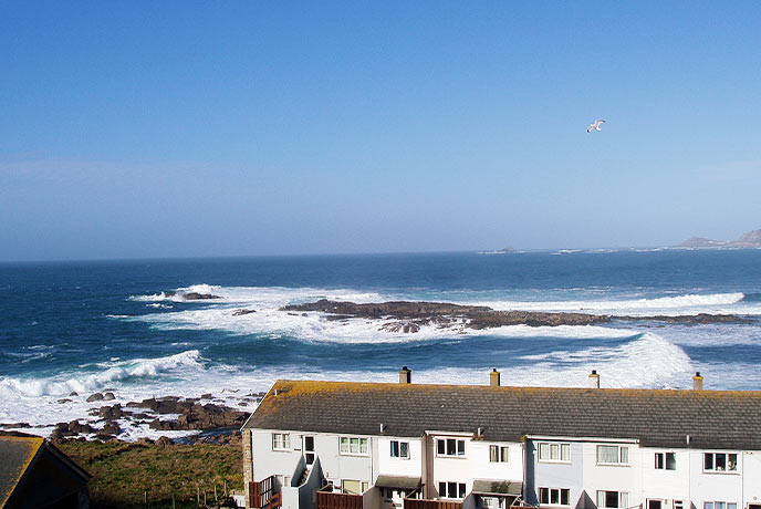 Giant waves rolling into shore behind the lovely holiday cottage Oystercatcher in Cornwall