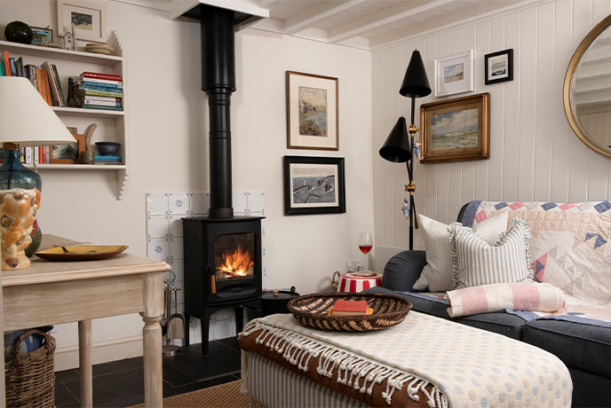 The cosy living room at Pink Cottage in Marazion with a lit wood-burner