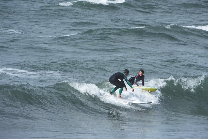Two boys surfing with Adventure Bay Surf School