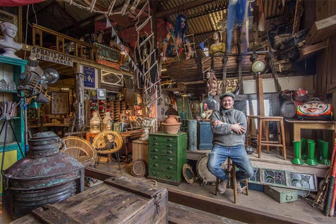One of the rooms full of reclaimed and salvaged treasures alongside the owner of Shiver Me Timbers, Joe