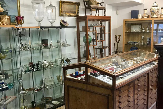 A collection of glass display cases full of antiques at The Emporium