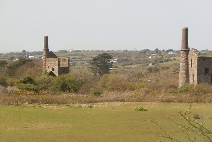 Two of the historic engine houses surrounded by countryside at King Edward's Mine Museum in Cornwall