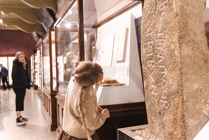 A child looking at an ancient stone in the Royal Cornwall Museum