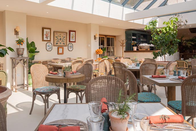 Lots of tables inside the bright and airy Orangery restaurant at the Duchy of Cornwall Nursery