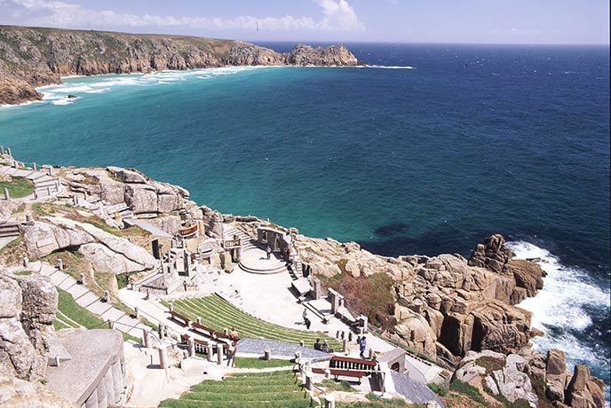 Looking down at the carved stone of Minack Theatre with west Cornwall in the background