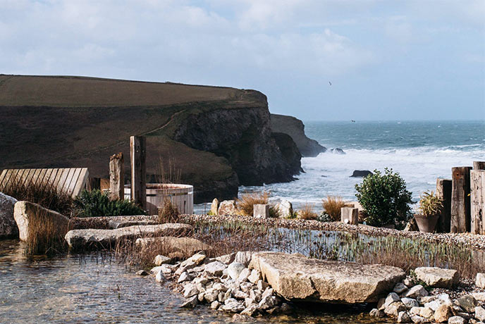 The beautiful cliff top hot tub at Scarlet Spa looking out over the cliffs, beach and sea beyond