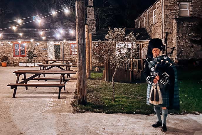 A bagpiper welcoming people to the Burns Night celebration at Knightor Winery in Cornwall