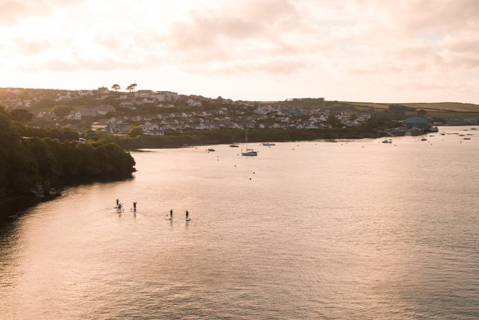 People paddle-boarding on the still waters by Padstow in North Cornwall