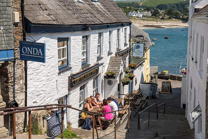 Looking down the cobbled steps in St Mawes at the sea with The Victory Inn on the side