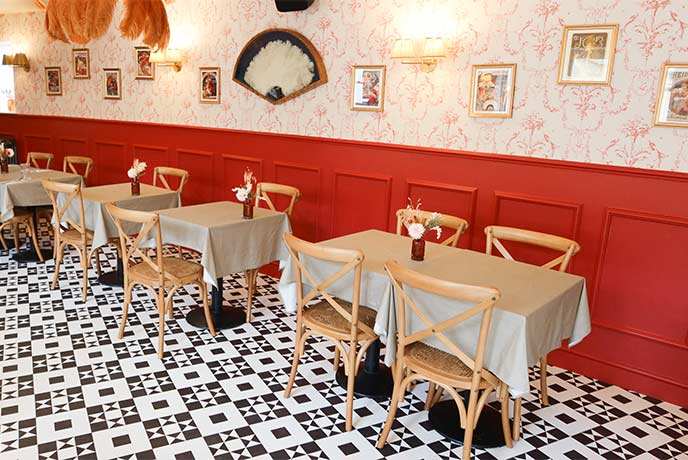 The stylish dining room at the Fleur de Lys restaurant in the Cotswolds with black and white flooring and red walls