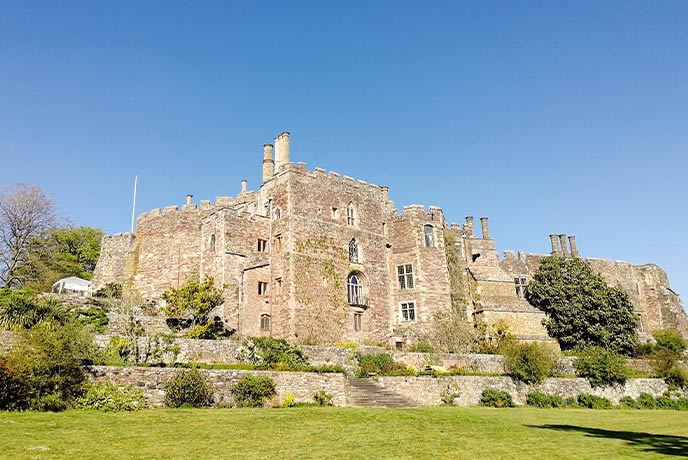 The golden-bricked exterior of Berkeley Castle in the Cotswolds