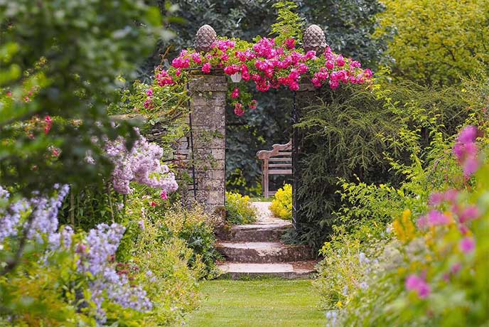 A beautiful, flower-lined garden path at Cerney House Garden in the Cotswolds