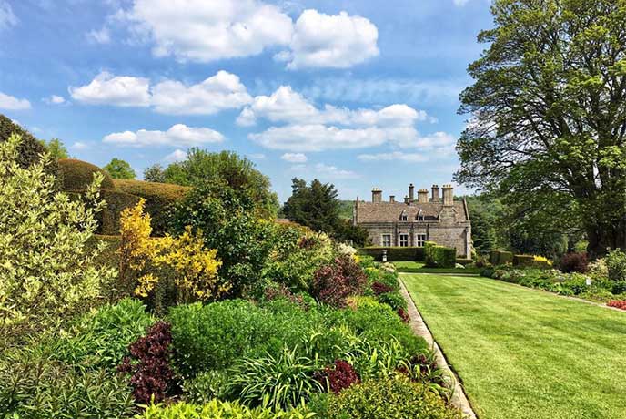 Beautiful manicured lawns and flowery borders at The Garden at Miserden in the Cotswolds