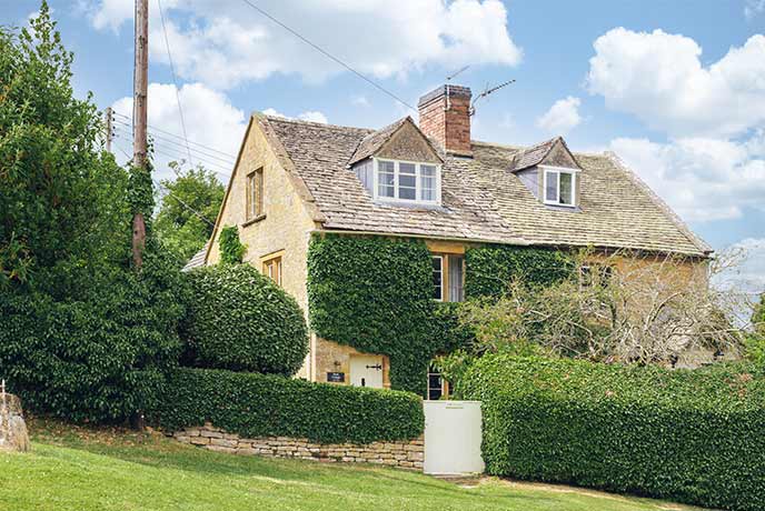 The beautiful gold-stone exterior of Bank Cottage in the Cotswolds