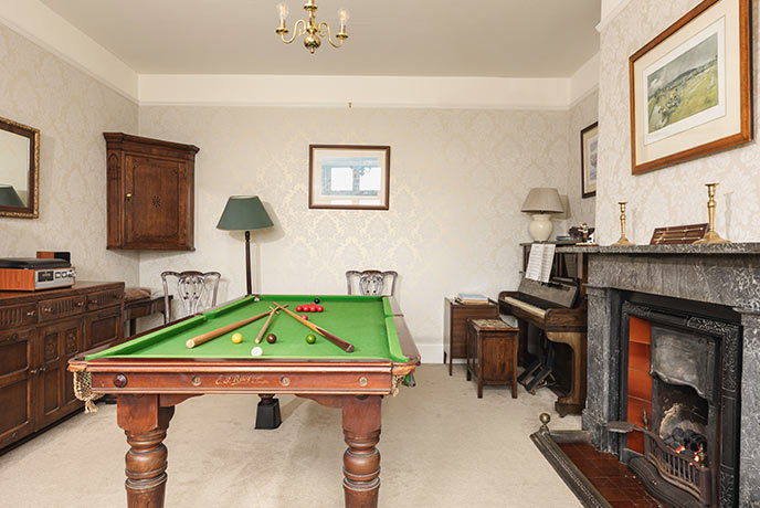 A vintage billiards table and piano in a beautiful games room in the Cotswolds