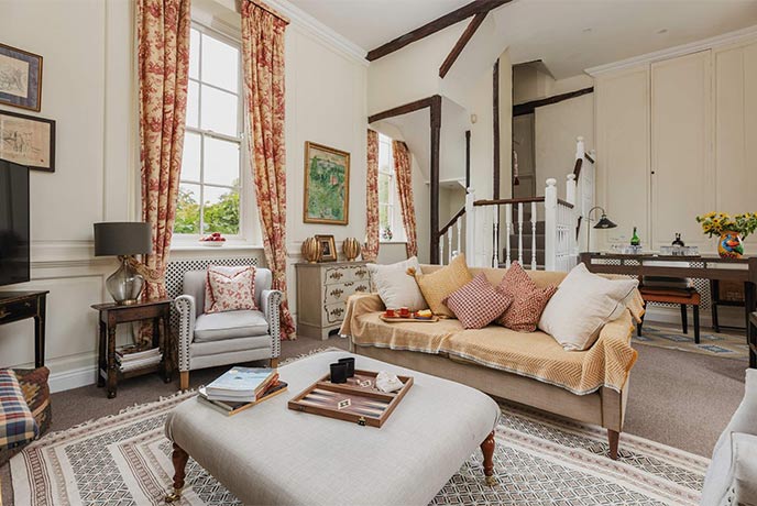 A cosy living room with board games and sofas at The Summer House in the Cotswolds