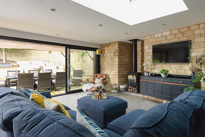 A large blue corner sofa in a spacious living area at Wold House in the Cotswolds