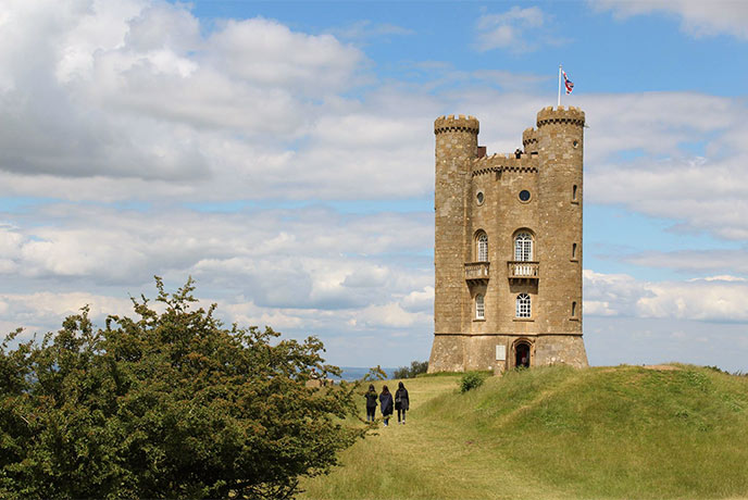 People walking towards Broadway Tower in the Cotswolds