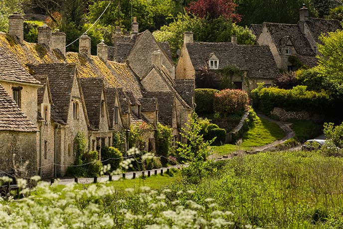 The famous Arlington Row in Bibury, lined with crooked cottages and flowers